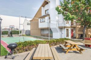 a picnic table and a grill with a basketball court at Hawthorn Suites Dayton North in Dayton