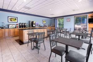 a restaurant with tables and chairs and a counter at Wingate by Wyndham Athens GA in Athens