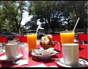 a red table with two glasses of orange juice at Plaza hotel in Dolores