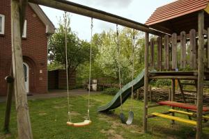 un parque infantil con un columpio y un tobogán en Holiday Home Op 't Busselen, en Opoeteren