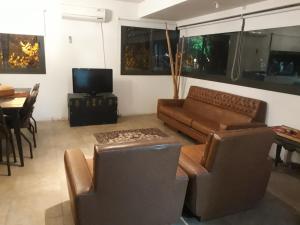 a living room with a couch and chairs and a television at Amplio y luminoso, 5ta sección in Mendoza