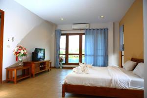 ノンナムデンにあるThongsathit Hill Resort Khao Yaiのベッドとテレビが備わるホテルルームです。