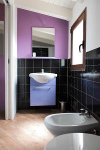 a bathroom with purple walls and a sink and a tub at Addisa Locazione Breve in Castellammare del Golfo