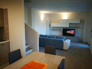 Appartamento Chiara في ليدرو: غرفة معيشة مع أريكة زرقاء وتلفزيون