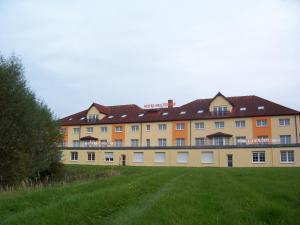 un gran edificio con un campo de hierba delante de él en Hotel Reuterhof en Reuterstadt Stavenhagen