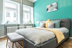 a bedroom with a bed with a blue wall at Greystone Suites & Apartments in Riga