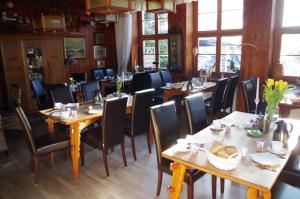 KluisにあるPension & Restaurant "Alte Schule"のダイニングルーム(木製のテーブルと椅子付)
