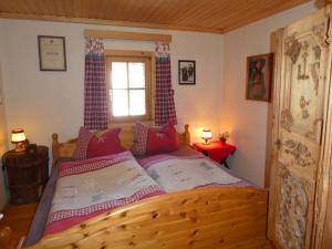 1 dormitorio con cama de madera y ventana en Ferienhaus Posthüttl, en Virgen
