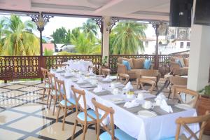 a table with white tables and chairs on a patio at Spice Palace Hotel in Zanzibar City