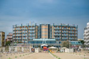 a large building on the beach in front of a building at Savoia Hotel Rimini in Rimini