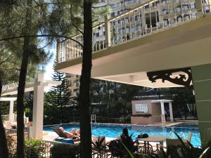 two people laying in a swimming pool in a hotel at Camella Northpoint Condo Studio in Davao City