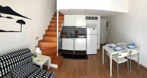 una cucina e un soggiorno con frigorifero bianco e tavolo di Ale & Tizy House a Napoli