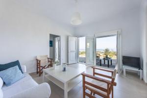 a living room with a white couch and a table at Vourvourou Sea View in Vourvourou