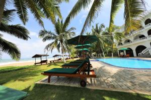 a row of chaise lounges next to a resort pool at Joe's Resort Bentota in Bentota