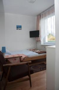 a bed in a room with a table and a window at APARTAMENT i pokoje Aura Dom Wczasowy in Darlowko