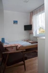 łóżko w pokoju ze stołem i oknem w obiekcie APARTAMENT i pokoje Aura Dom Wczasowy w Darłówku