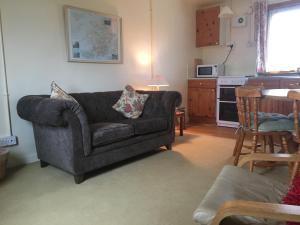 a living room with a couch and a kitchen at Shieling Holidays Mull in Craignure