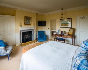 a bedroom with a bed and a desk and a fireplace at Greywalls Hotel & Chez Roux in Gullane