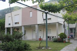 a large white building with trees in the yard at Apartments Grgurević in Kotor