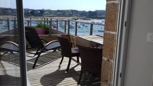 a balcony with chairs and a view of a marina at Hôtel des Rochers in Perros-Guirec