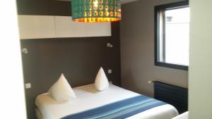 a bedroom with a bed and a chandelier at Hôtel des Rochers in Perros-Guirec