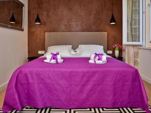 a purple bed with two pink pillows on it at Luxury room Colonna 4*, center in Zadar