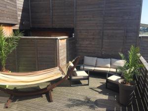 a hammock and a couch on a patio at Hôtel des Rochers in Perros-Guirec