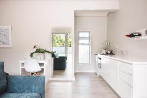 a kitchen and living room with a blue couch at A Riverbed Guesthouse in Swellendam