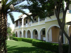 a large white building with trees in front of it at Tereza Apartments in Acharavi