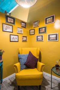 a yellow chair in a room with yellow walls at Y.Baixa - Boutique Apartments in Setúbal
