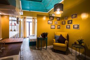 un salon avec des murs jaunes et une chaise jaune dans l'établissement Y.Baixa - Boutique Apartments, à Setúbal