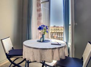 a table with a vase of flowers on top of a window at RIVIERA STUDIO CANNES CENTER in Cannes