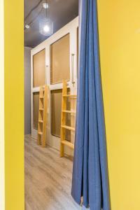 モスクワにあるCapsule hostel "Sleep QB" Novoslobodskayaの青いカーテンと黄色い壁の部屋
