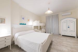 um quarto branco com uma cama branca e uma porta branca em Casa Vacanze Poseidone em Lido Conchiglia