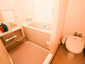 a bathroom with a toilet and a bath tub at APA Hotel Sapporo Susukino Ekimae in Sapporo