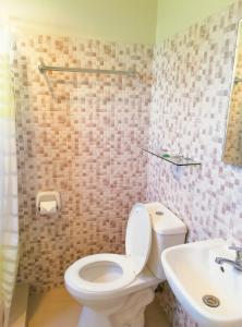 a bathroom with a toilet and a sink at Veranda Residence Inn in Tacloban