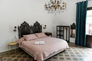 - une chambre avec un grand lit et un lustre dans l'établissement B&B Malvasia, à Palerme