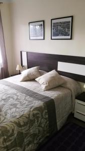 a bedroom with a large bed and two pictures on the wall at Casa El Serrat del Tell in Sant Pau de Segúries