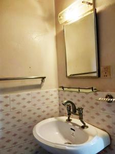 uma casa de banho com um lavatório e um espelho em 行者之家SUNFLOWER em Rummindei