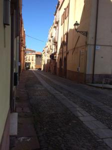 una calle vacía en un callejón entre edificios en Aghinas, en Bosa