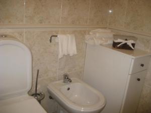 a small bathroom with a toilet and a sink at Casa do Terraço in Aveiro