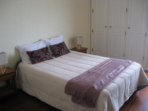 um quarto com uma cama grande e 2 mesas de cabeceira em Casa do Terraço em Aveiro