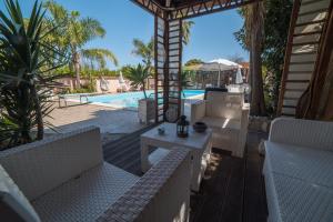a patio with white furniture and a swimming pool at All'Ombra Del Noce B&B in Catona