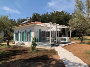 a small white house with blue windows and a porch at Beach Villa Isidora in Potos