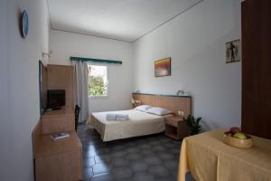 a hotel room with a bed and a television at SUN -RISE in Perissa
