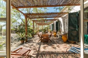 a patio with a table and chairs under a pergola at B&B La casa di Pippinitto in Santa Venerina