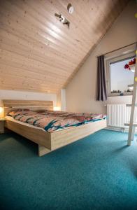 a bedroom with a bed with a wooden ceiling at Ferienhaus Nordhorn - Haus Am See in Nordhorn