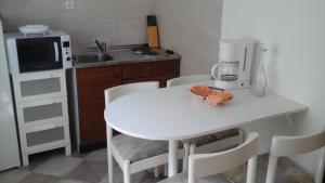 a kitchen with a white table and a microwave at Guesthouse Familija Tariba in Supetarska Draga +19 photos