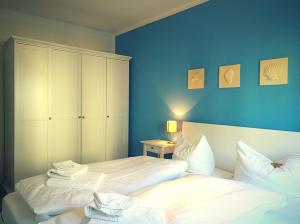 a bedroom with two beds and a blue wall at Ferienwohnung Strandhafer - nur 300m vom Meer in Kühlungsborn