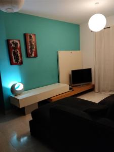 a living room with a couch and a television at Paceville Avenue Apartment in St. Julianʼs